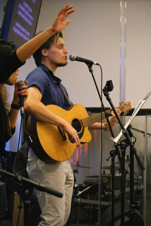 a man that is holding a guitar on stage