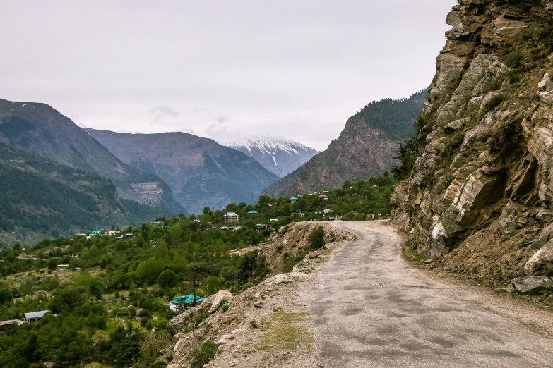 a long road in the mountains with trees on both sides