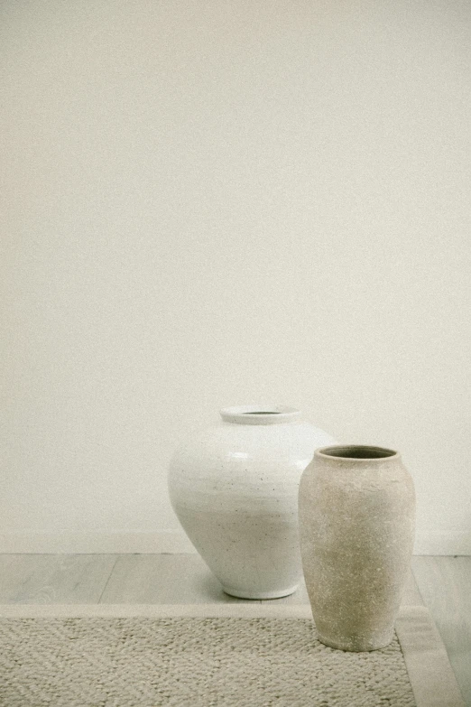 three large white vases sitting next to each other