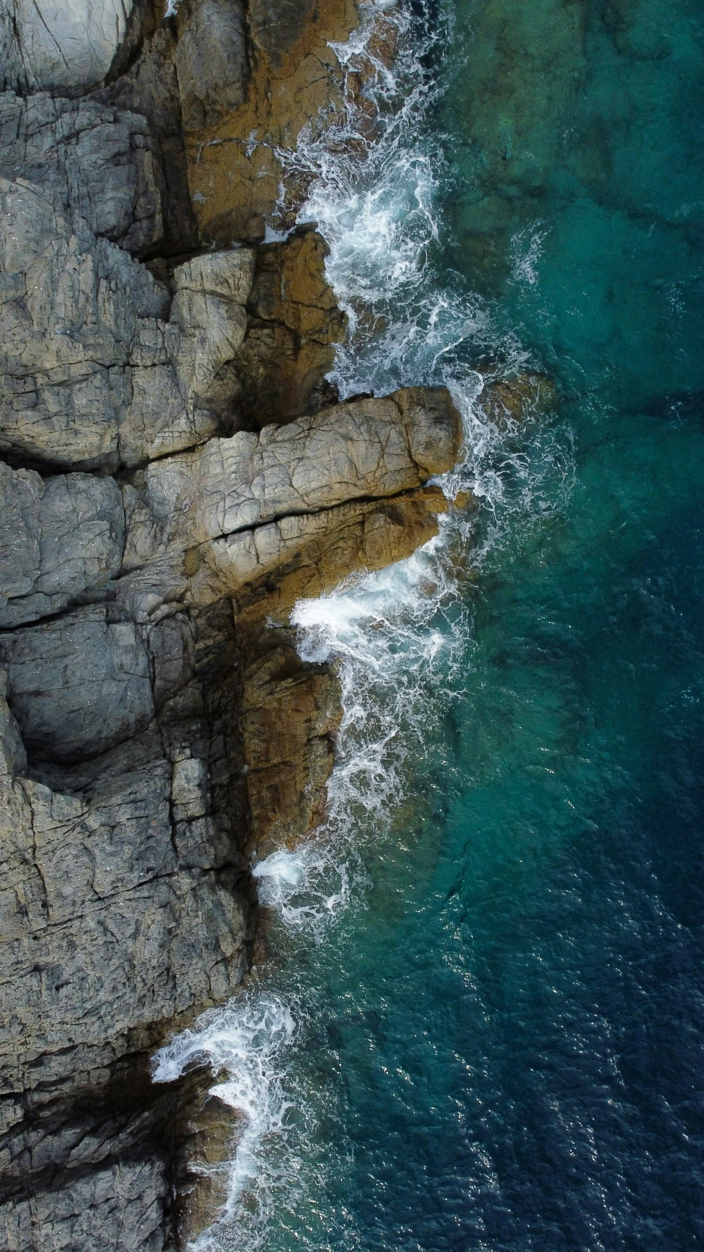 a rock face and a body of water near one another