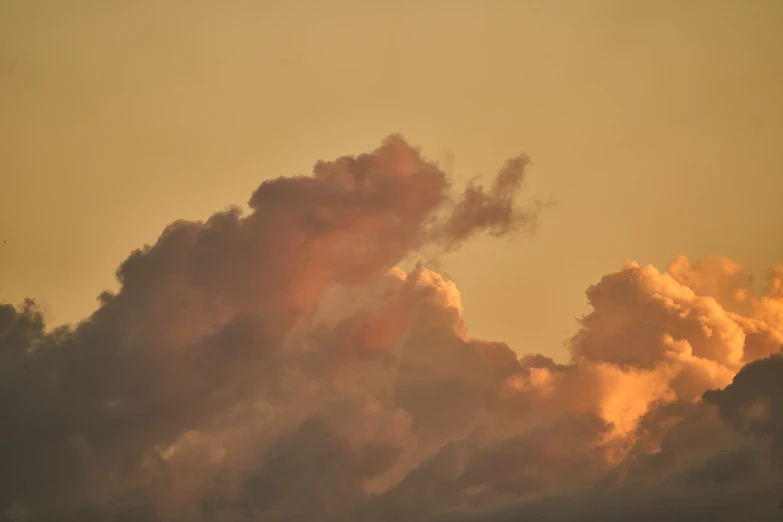 an airplane flying over some clouds and sunset