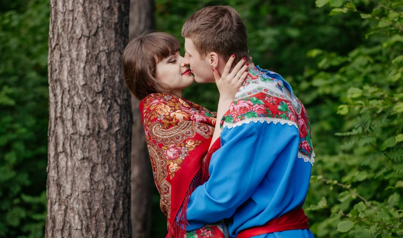 a couple emce with each other in a forest