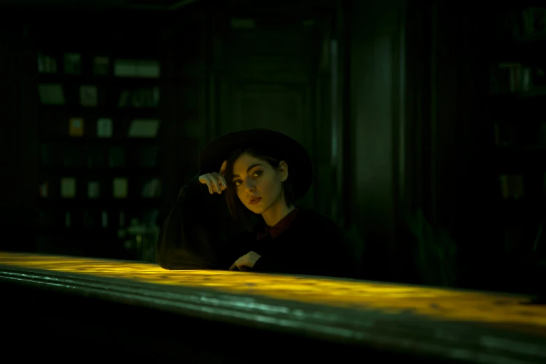 a woman wearing a black hat in front of some books