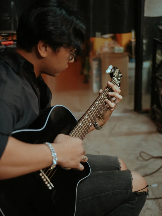 a man playing the guitar with his hands