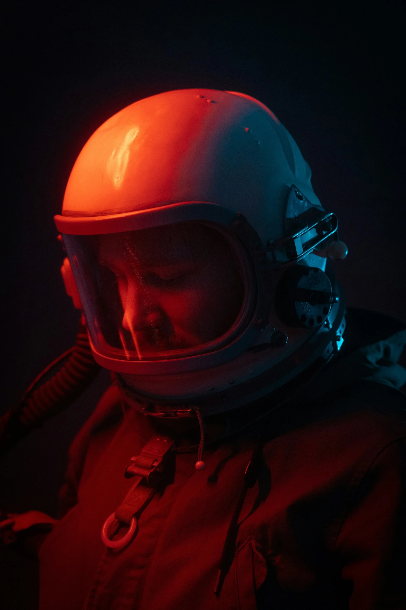 a man in a helmet with red lighting shining on his face