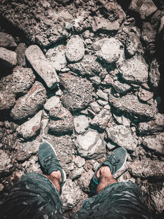 a person standing on top of rocks next to water