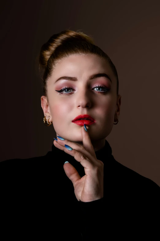 a beautiful blonde woman posing with her hand under her chin