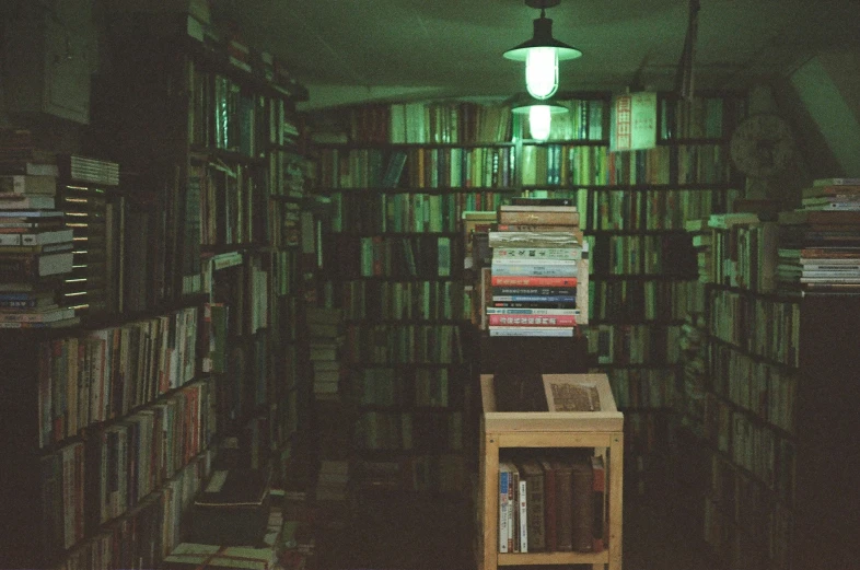 a dark room with lots of books and a lamp