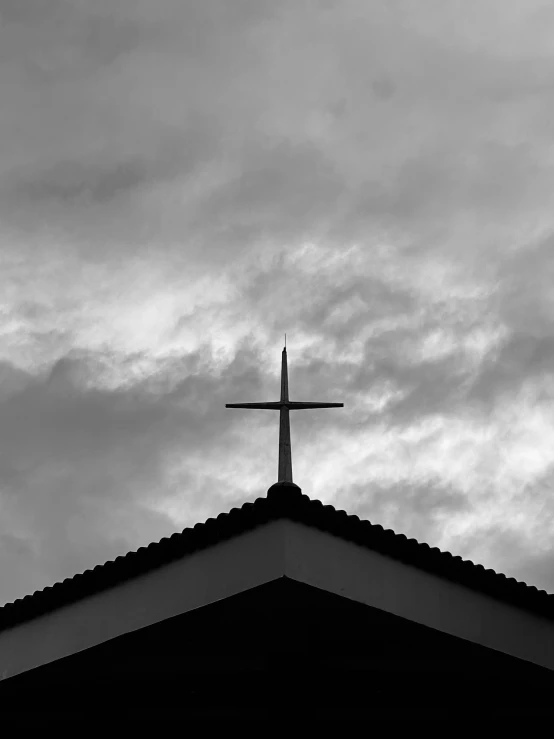 a big white cross with clouds in the background