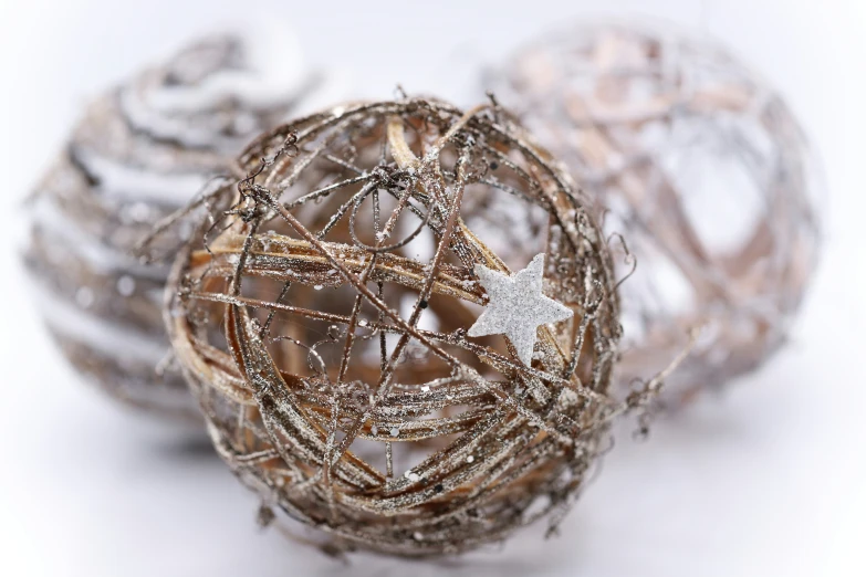 three christmas balls sitting side by side with some thread all over them