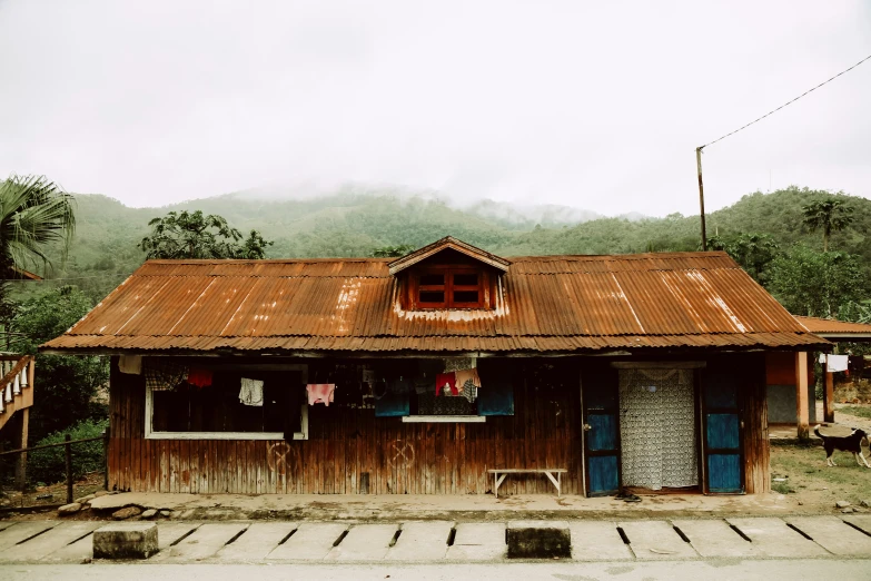 an old building with a rust roof in the middle of the day