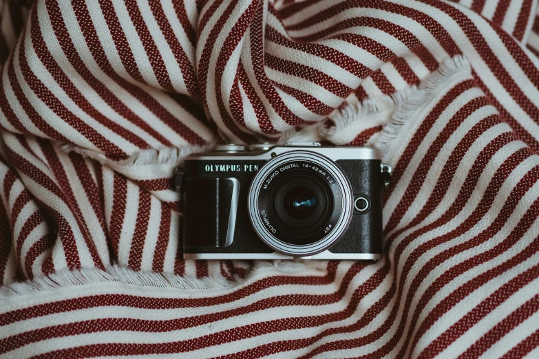 a camera sitting on top of a bed covered in blankets