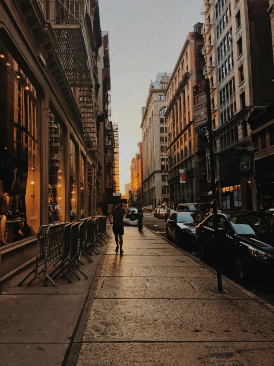 people walking down the sidewalk in a city at night