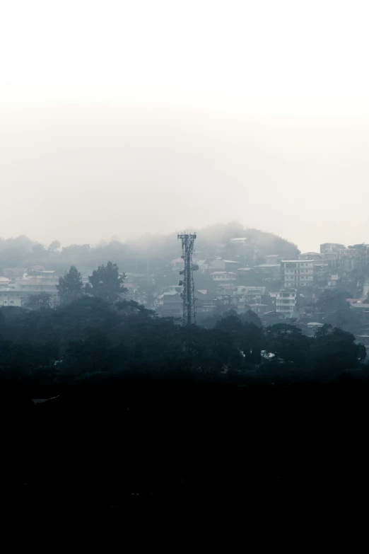 a city is covered in fog by the tall tower