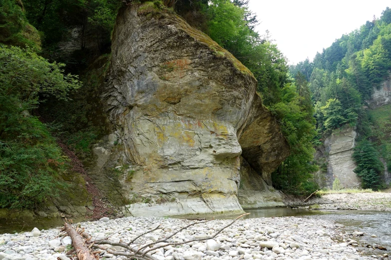 a person standing next to a rocky river