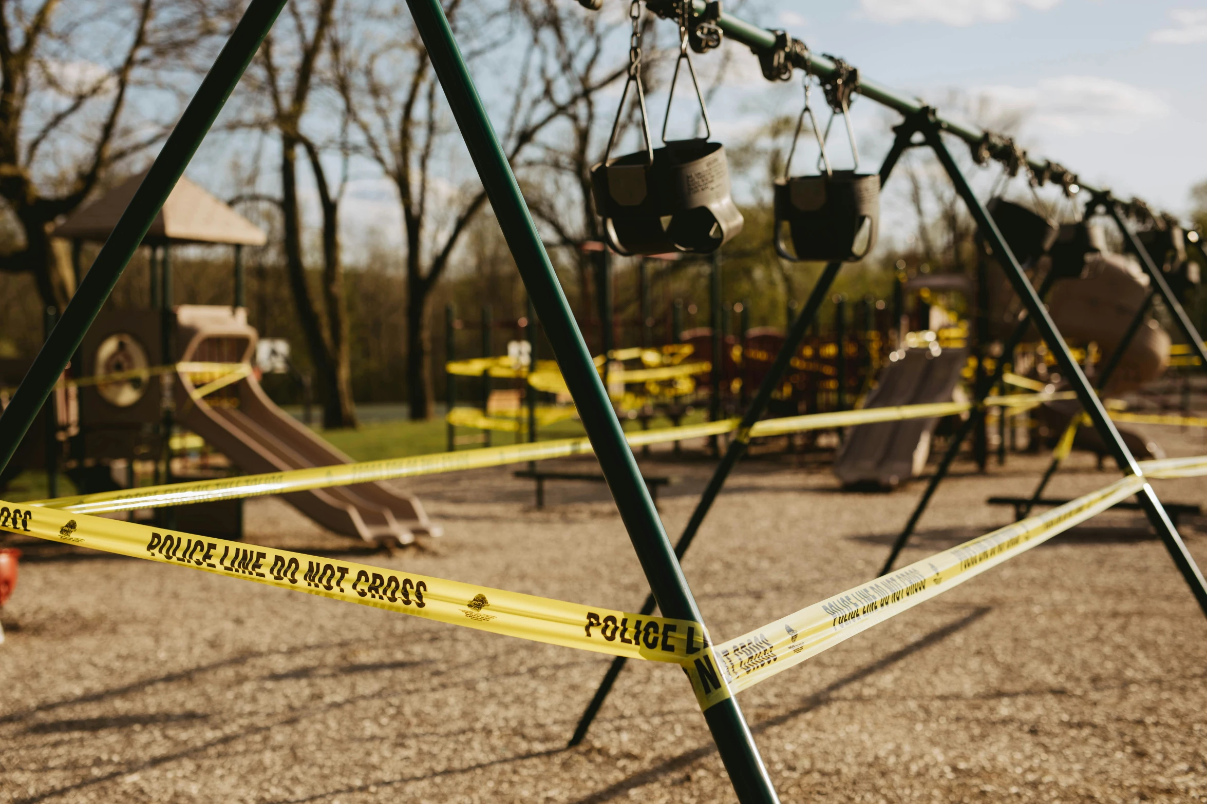 a police tape that has been taped across the edges of an empty playground area