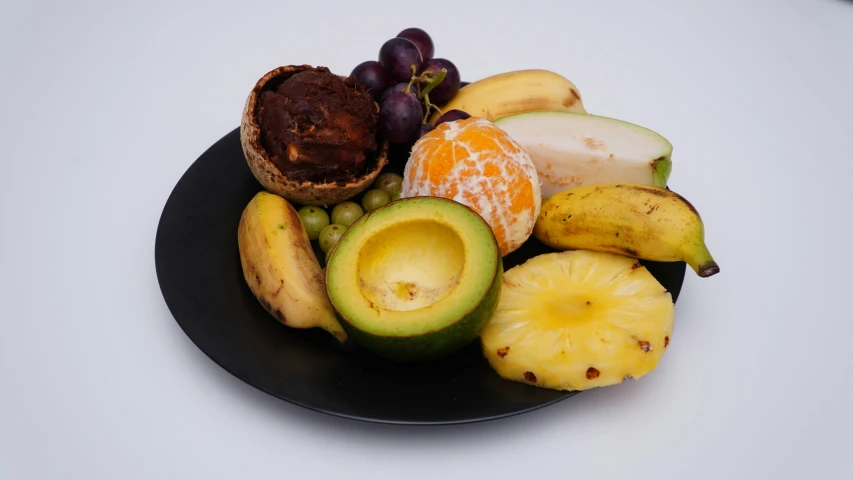 some fruits and pieces of fruit sitting on a plate