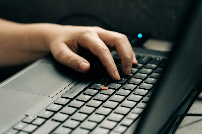 someone working on a laptop while touching the keys