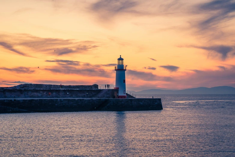 a lighthouse surrounded by water and a sky background