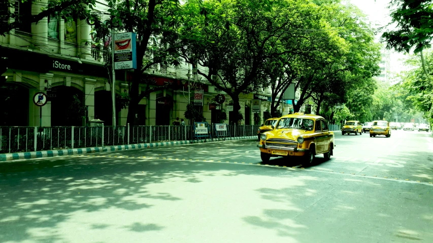 a row of taxis are lined up along the side of the street