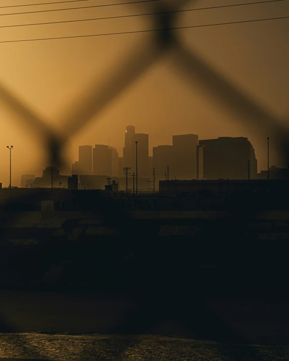 a tall city skyline standing through a fence