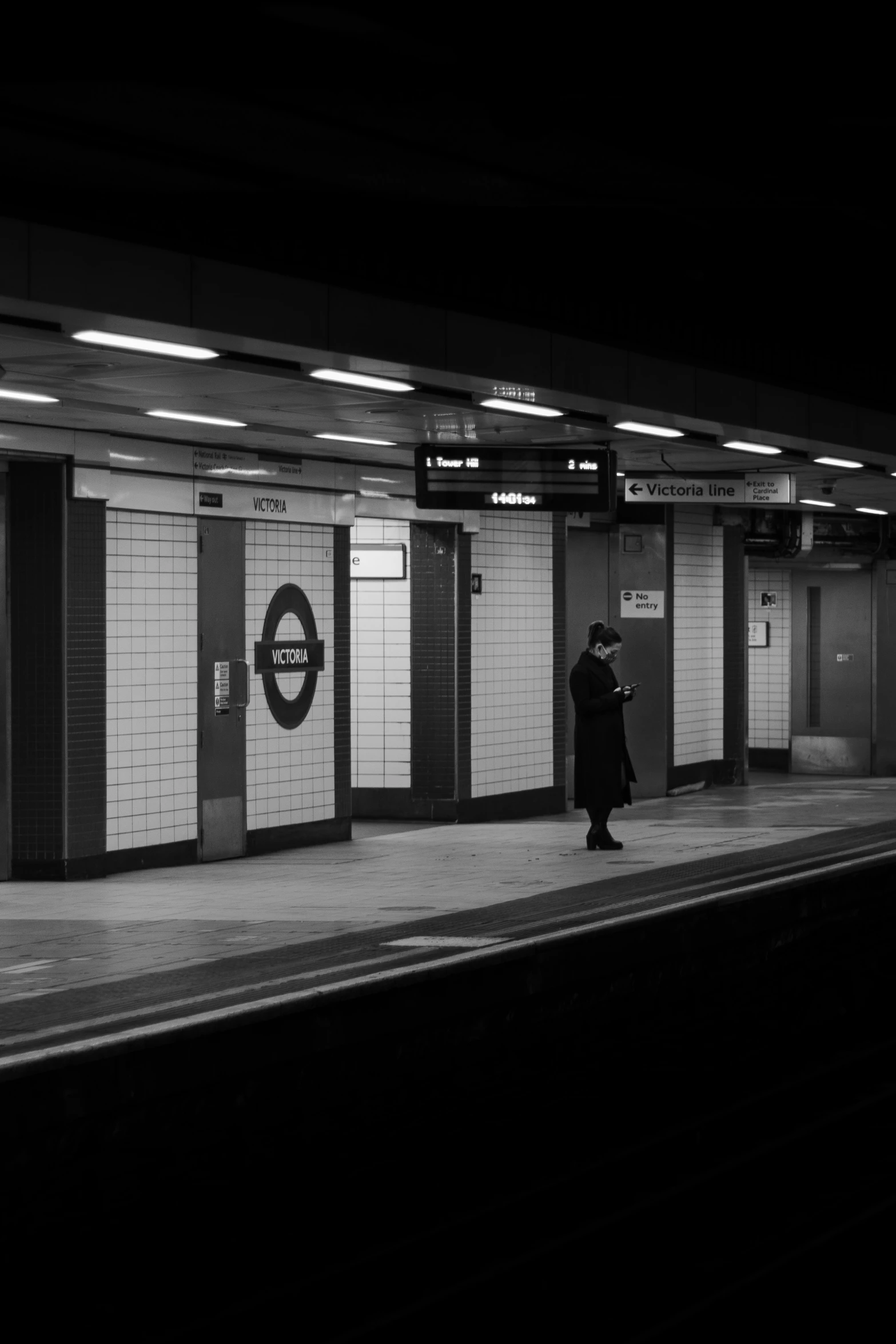 a subway station with an old man in a long coat walking past