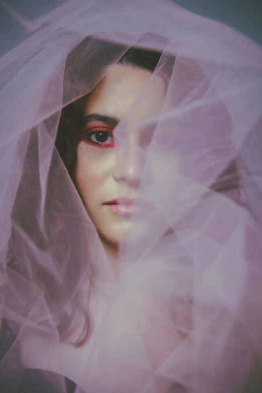 a close up view of a woman's face covered in veil