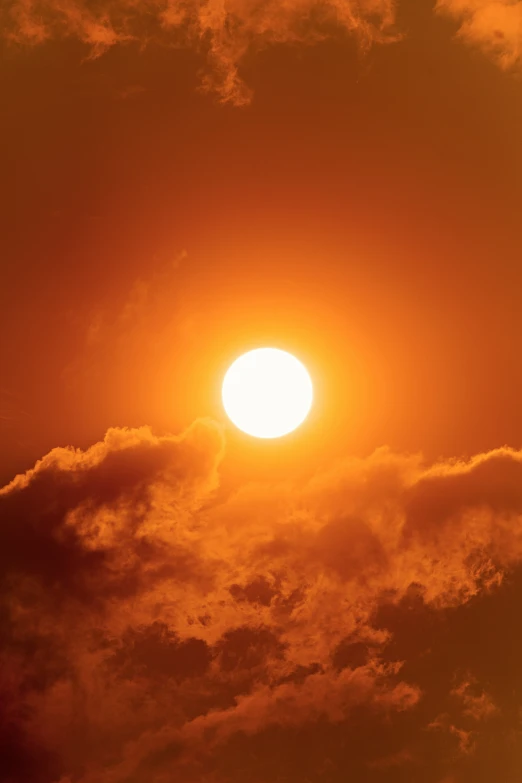 the bright sun setting behind an airplane as it flies high in the air