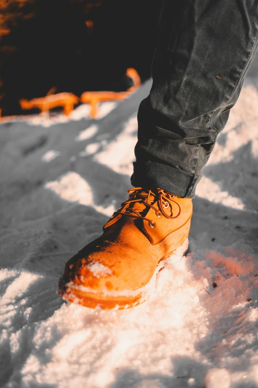 a person in yellow shoes standing in the snow