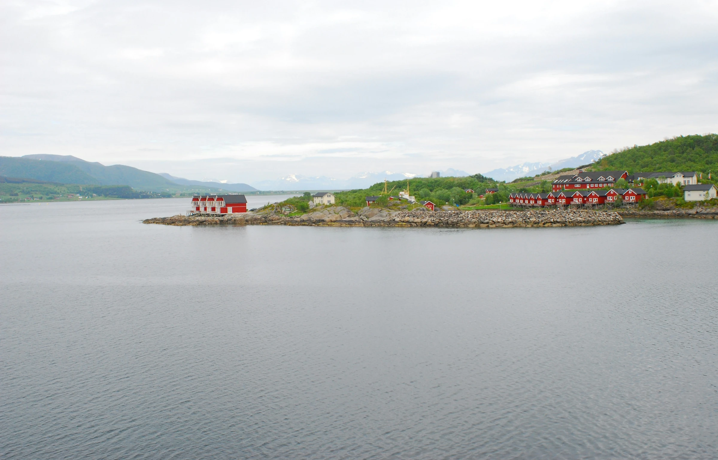 there are several houses on the water and red buildings