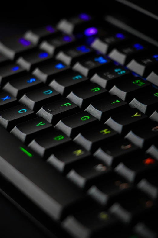 a computer keyboard with a glowing green and blue key