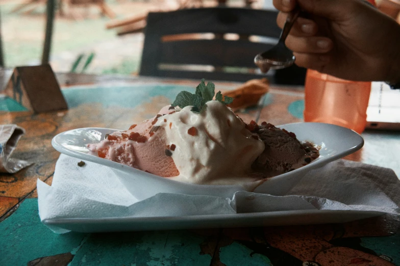 a person with their food in a bowl at a table