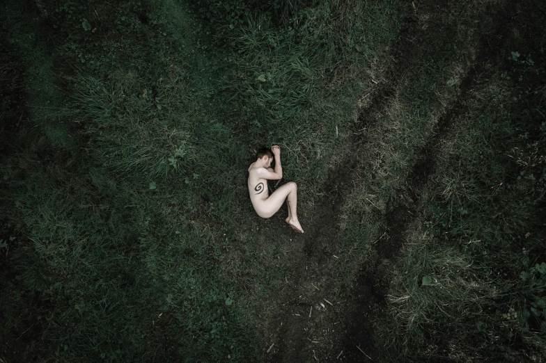 a  man sits in grass with his hands in his hair