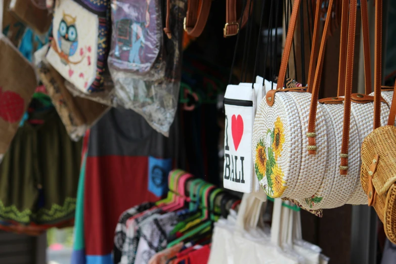 many bags hang up against the wall with different designs