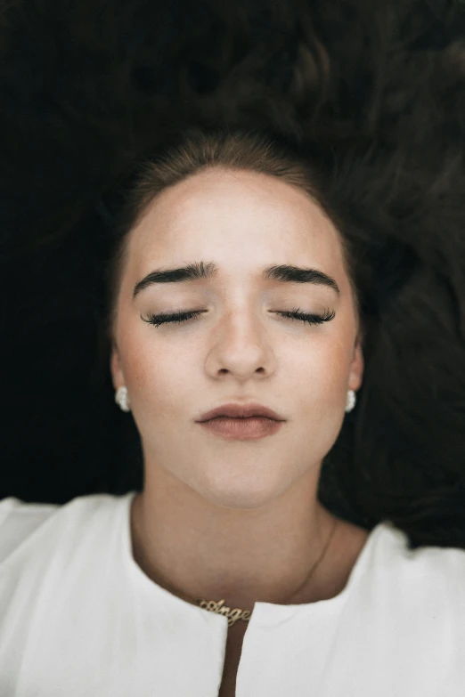 a woman is seen laying down with her eyes closed