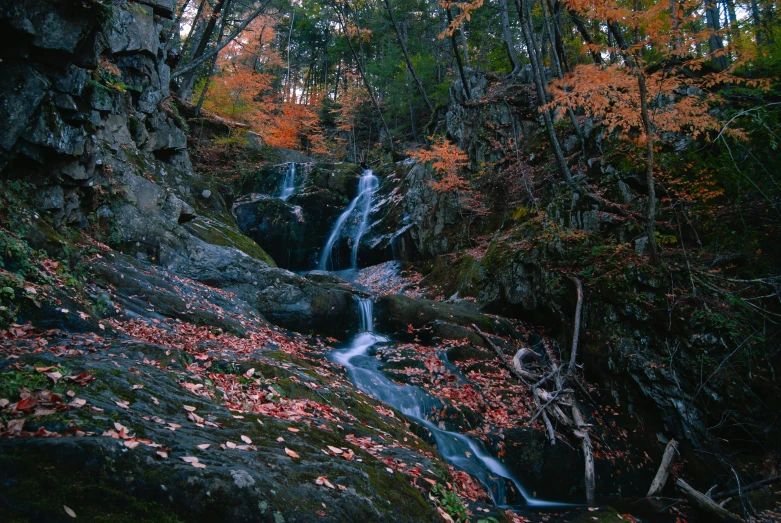 a large waterfall sits on a steep hill in the fall