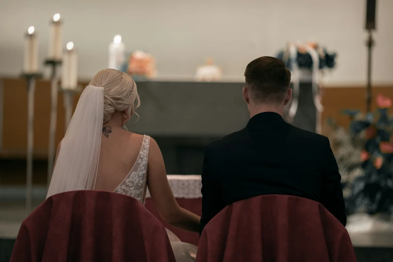 a man and woman dressed in white sitting next to each other