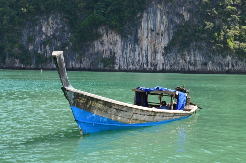 a boat with a motor on the water near rocky cliffs