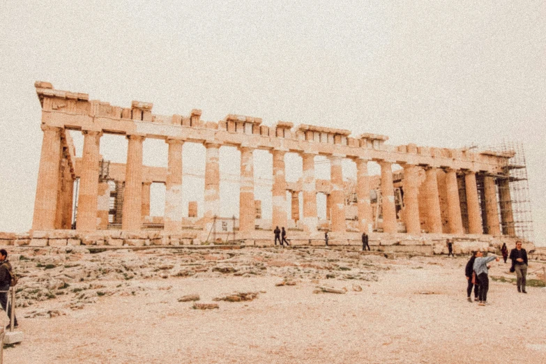 a group of people walking around in front of a very old building