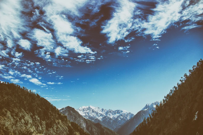 snow - capped mountains in the distance and a road running through them