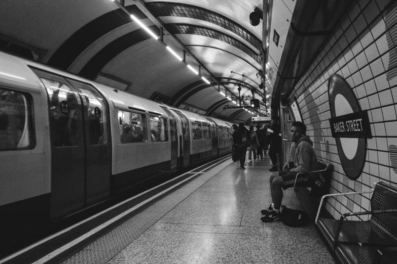 people walk down the platform beside a subway train