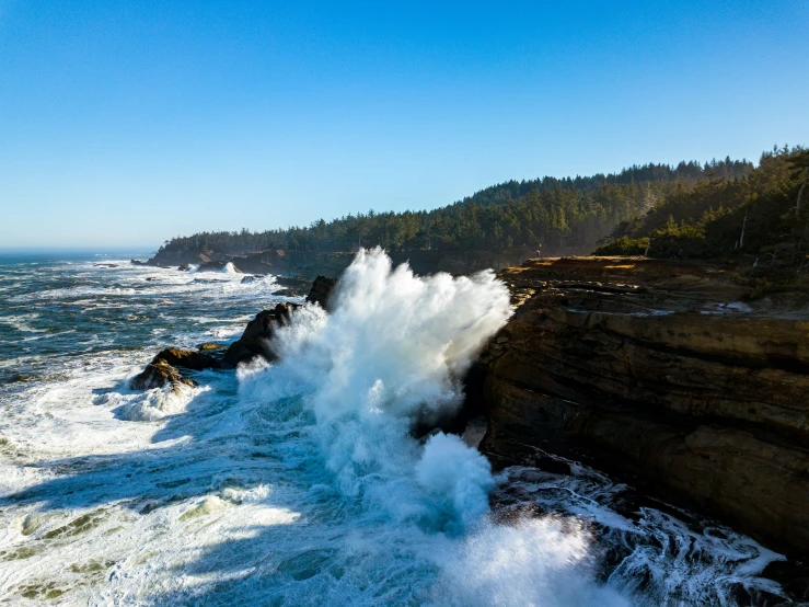 waves break onto the coast as it breaks into the cliffs