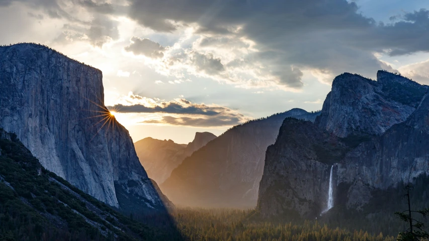 mountains surrounded by evergreen and pine trees under a sunset