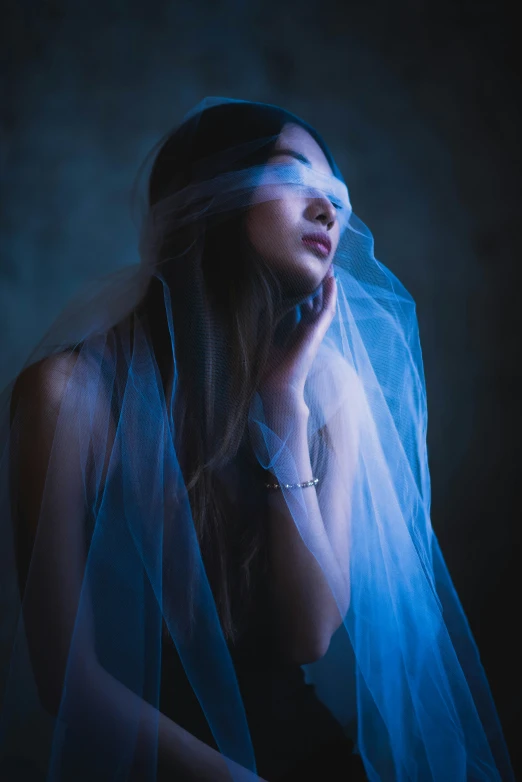 the woman is posing while wearing a veil