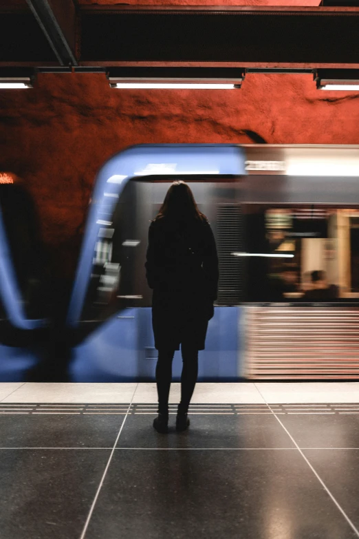 a person standing in front of a subway train