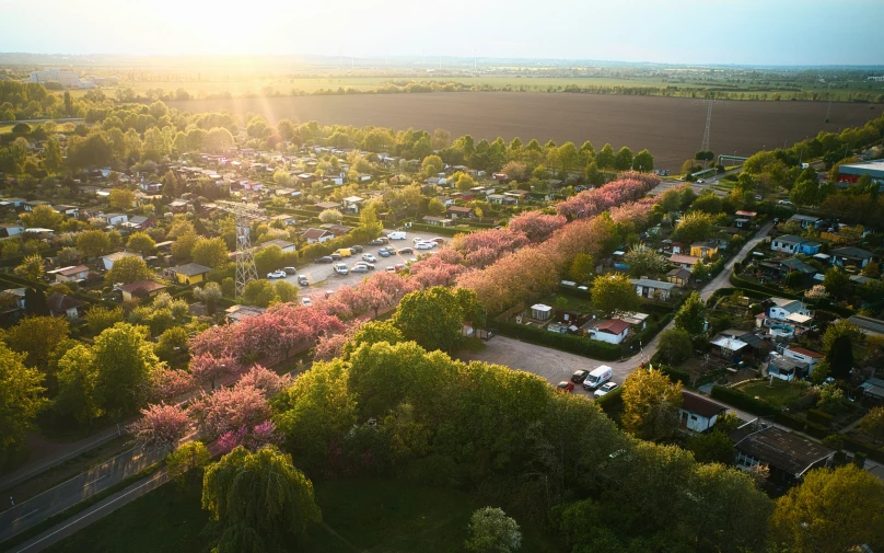 the sun shines brightly over a parking lot and many trees