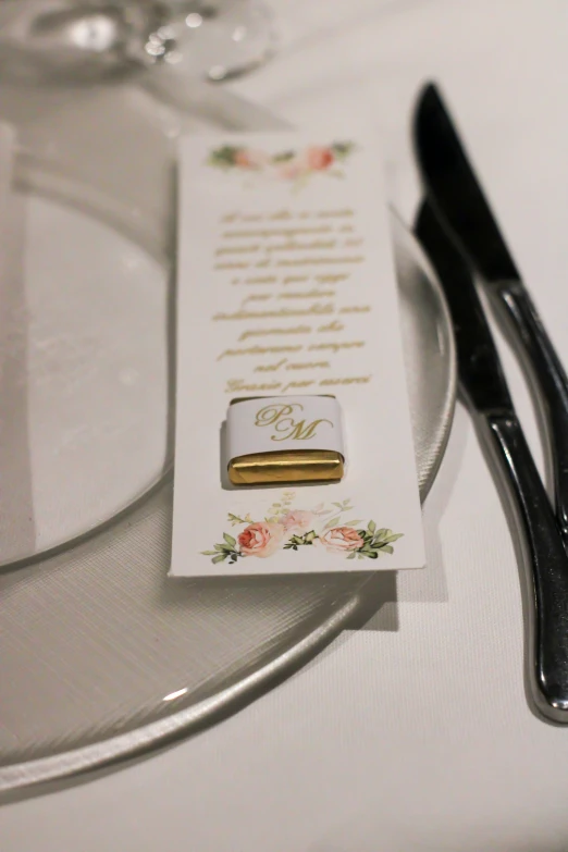 a white card with a gold foiled object on it
