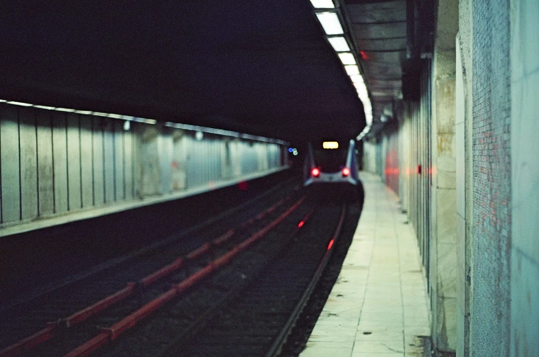 a subway station at night with cars coming out of it