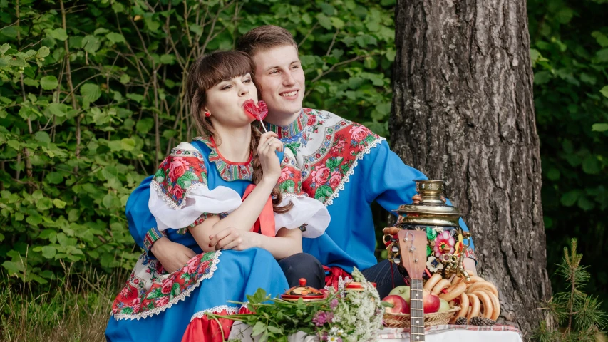 a man and a woman sitting in front of a cake