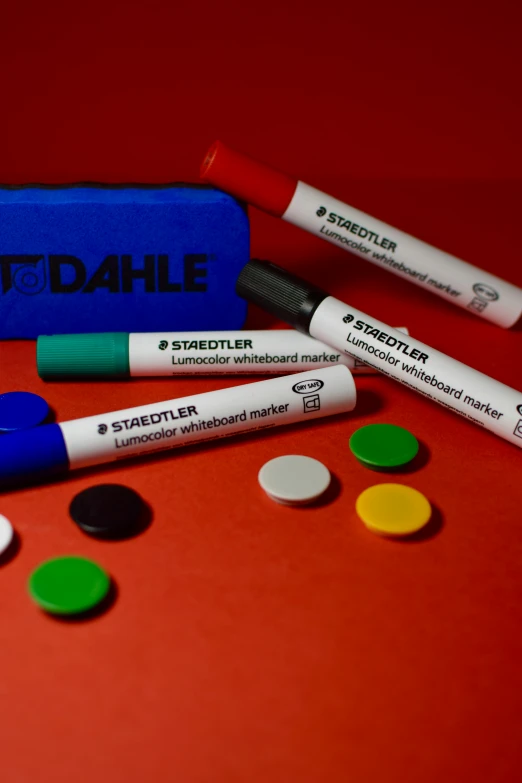 some colorful pill markers and an eraser on a red table